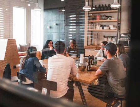 Sete pessoas ao redor de uma mesa discutindo como usar inbound marketing para brand awareness.