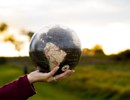 A closeup shot of a female holding a globe with a blurred background